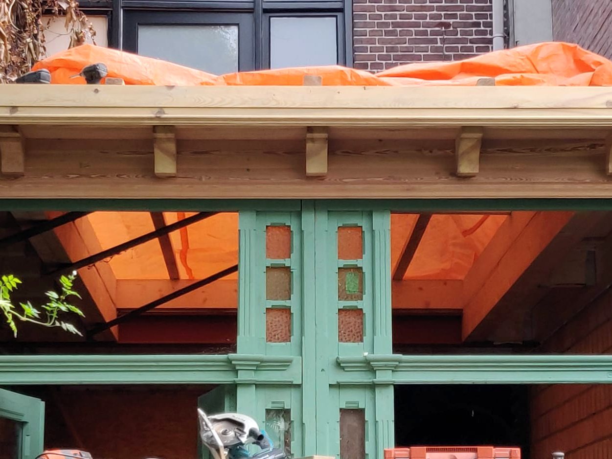 Houten pui in aanbouw, het dak nog onder zeil